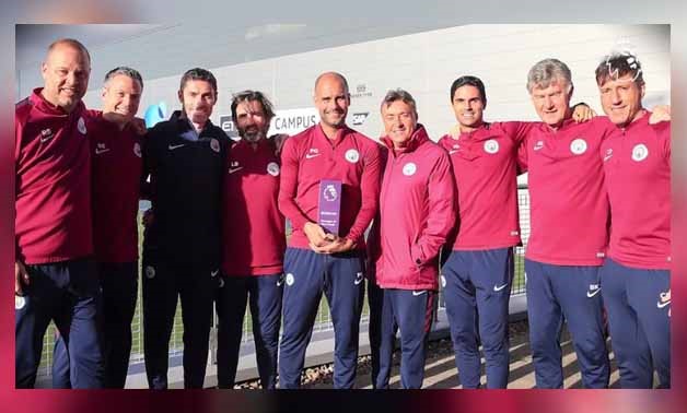 Pep Guardiola with his award among his coaching staff - Premier League official website