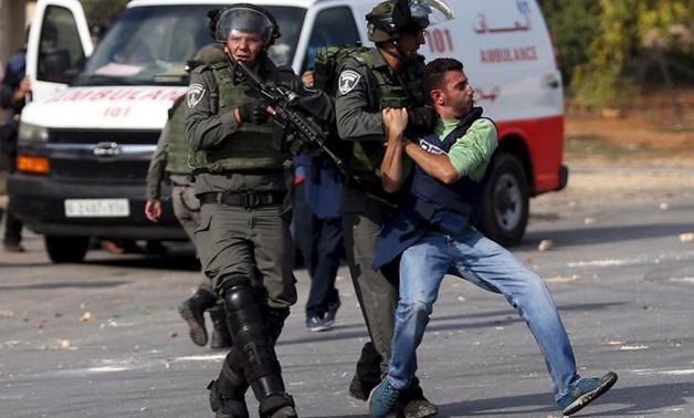 FILE - Israeli police arresting a journalist in the West Bank - REUTERS