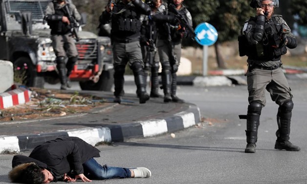 A Palestinian man lies on the ground after being shot by Israeli border policemen near the Jewish settlement of Beit El, near the West Bank city of Ramallah December 15, 2017 REUTERS