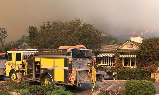 Firefighters provide structure protection at the historic San Ysidro Ranch as flames from the Thomas Fire, now the third-largest on record, rage in the distance in Montecito, California, U.S., December 16, 2017. Courtesy Mike Eliason/Santa Barbara County 