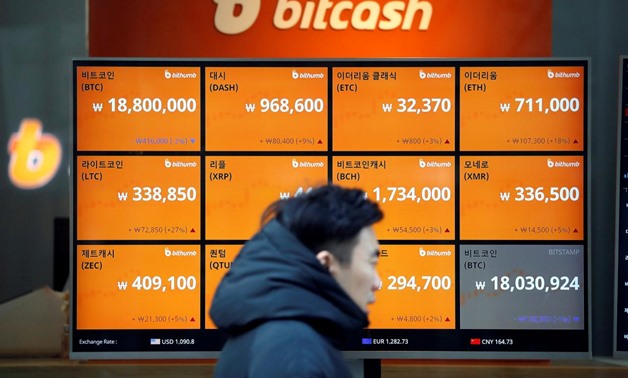 A man walks past an electric board showing exchange rates of various cryptocurrencies including Bitcoin (top L) at a cryptocurrencies exchange in Seoul, South Korea December 13, 2017. REUTERS/Kim Hong-Ji