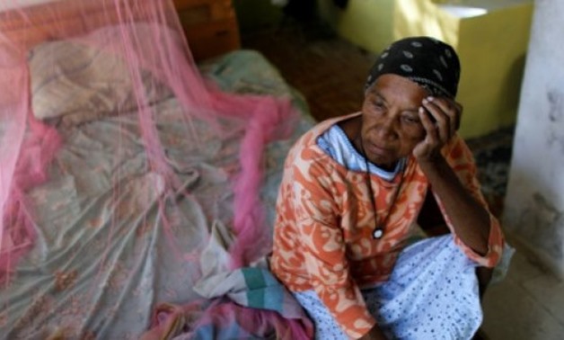 © AFP | Aurea Cruz, 66, sits on her bed inside her house damaged by Hurricane Maria in Vieques, Puerto Rico
