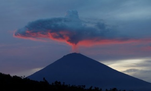 A plume of smoke above Mount Agung volcano is illuminated at sunset as seen from Amed, Karangasem Regency, Bali, Indonesia, November 30, 2017. REUTERS/Darren Whiteside
