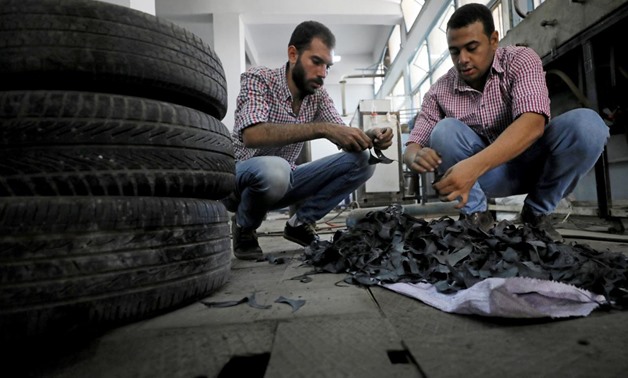Engineering students, Mostafa Saeed Ali and Mohamed Amr cut up car tires in Cairo, Egypt August 23, 2017 -
 REUTERS/Mohamed Abd El Ghany