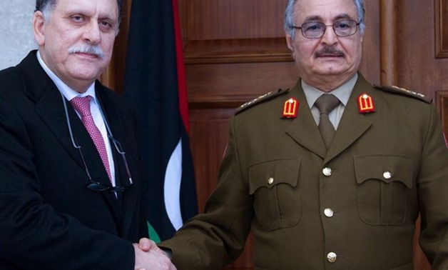 General Khalifa Haftar (R), commander of the armed forces loyal to the internationally recognized Libyan government, shakes hands with the head of the UN backed Libyan Presidential Council, Fayez al-Sarraj, in 2016- AFP