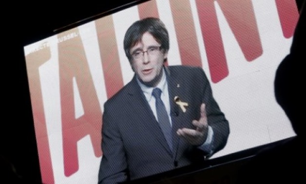 © AFP / by Laurence BOUTREUX | Deposed Catalan regional president Carles Puigdemont speaks via video-conference from Brussels during the final campaign meeting for the upcoming Catalan regional election on December 19, 2017 in Barcelona