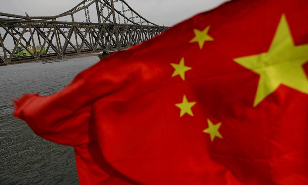 A Chinese flag is seen in front of the Friendship bridge over the Yalu River connecting the North Korean town of Sinuiju and Dandong in China's Liaoning Province on April 1, 2017. REUTERS/Damir Sagolj/File Photo