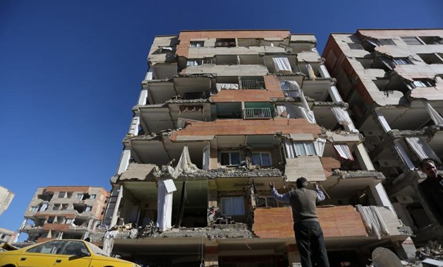 A man reacts as he looks at a damaged building in Sarpol-e Zahab county in Kermanshah, Iran. REUTERS/Tasnim News Agency