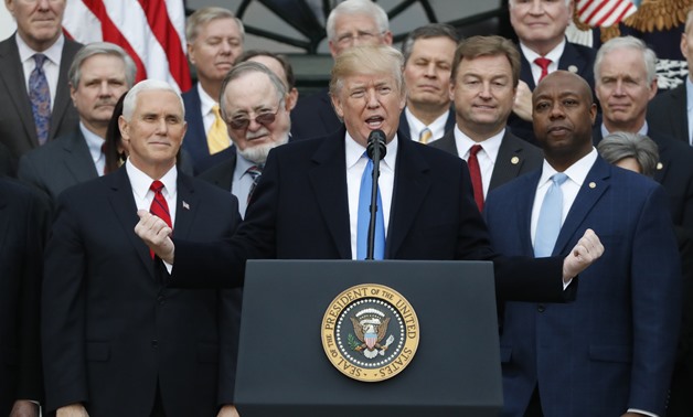 U.S. President Donald Trump speaks flanked by Vice President Mike Pence and Senator Tim Scott (R) as he celebrates with Congressional Republicans after the U.S. Congress passed sweeping tax overhaul legislation, on the South Lawn of the White House in Was