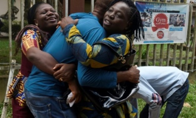 © AFP / by Sophie BOUILLON | A returnee migrant (C) brought home from Libya is embraced by relatives in Benin, capital of Edo State in midwest Nigeria on December 7, 2017. Out of over 400 Nigerian migrants that voluntarily returned from Libya, more than h