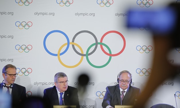 Mark Adams, IOC communication manager, Samuel Schmid, Chair of the IOC Disciplinary Commission, and Thomas Bach, President of the International Olympic Committee, attend a news conference after an Executive Board meeting on sanctions for Russian athletes,