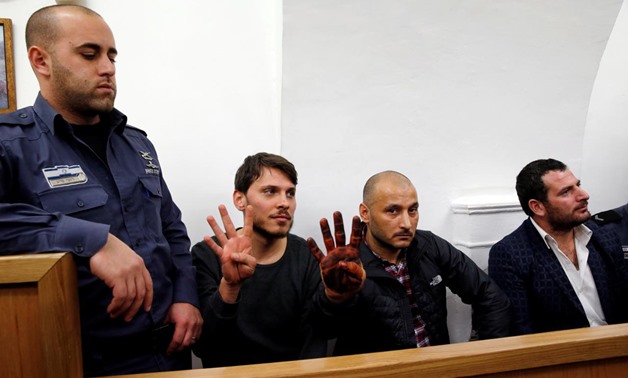 Three Turkish tourists whom Israeli authorities have arrested in Jerusalem over an incident that followed Muslim prayers at a flashpoint holy site according to a police spokesman, gesture at court in Jerusalem December 23, 2017. REUTERS/Ammar Awad