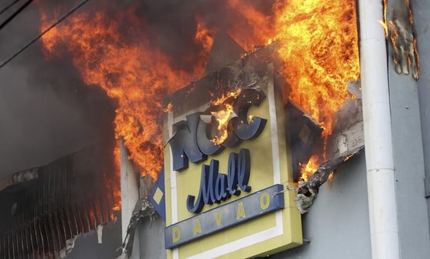  A fire rages on at the NCCC shopping mall in Davao: dozens of people are thought to have been trapped inside. Photograph: Manman Dejeto/AFP
