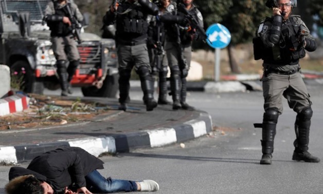 A Palestinian man lies on the ground after being shot by Israeli border policemen near the Jewish settlement of Beit El, near the West Bank city of Ramallah December 15, 2017 REUTERS