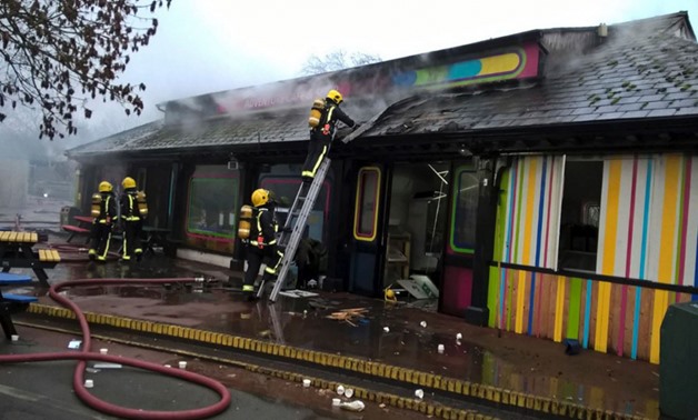 In this handout photo provided by the London Fire Brigade, firefighters work at the scene at Adventure cafe and shop near the Meerkat enclosure at London Zoo - AFP