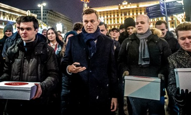 © Dmitry Serebryakov, AFP | Supporters of Russian opposition leader Alexey Navalny (C) carry boxes with signatures to nominate him as opposition candidate for the forthcoming presidential election in Moscow on December 24, 2017. Alexei Navalny, seen as th