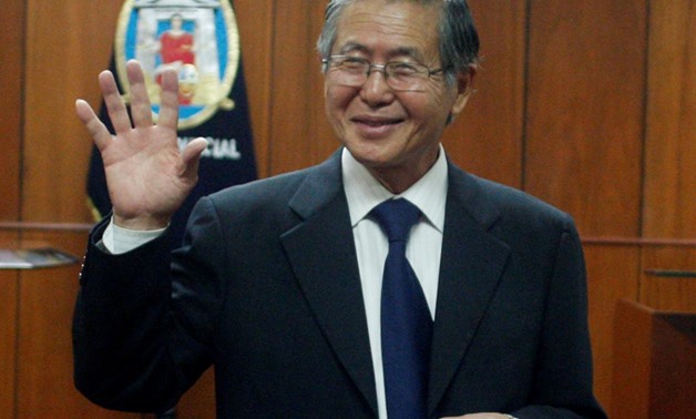 Peru's former President Alberto Fujimori waves as he enters the courtroom before his trial at the Special Police Headquarters in Lima April 1, 2009. REUTERS/Pilar Olivares/File Photo
