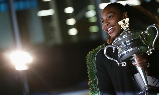 Tennis - Australian Open - Melbourne Park, Melbourne, Australia - early 29/1/17 Serena Williams of the U.S. poses with the Women's singles trophy after winning her final match. REUTERS/Edgar Su