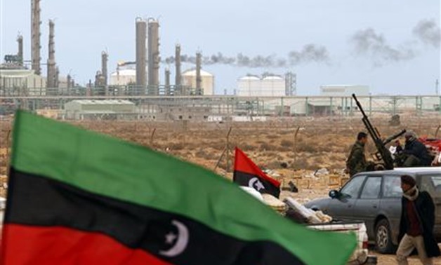 The Kingdom of Libya flag flies in front of a refinery in Ras Lanuf in this March 8, 2011, file photo. REUTERS/Goran Tomasevic