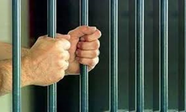FILE – Prisoner behind bars