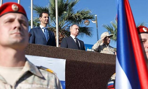 © AFP | A picture posted on the official Facebook page of the Syrian Presidency on December 11, 2017 shows Russian President Vladimir Putin and Syrian President Bashar al-Assad at a military parade in the Syrian province of Latakia.
