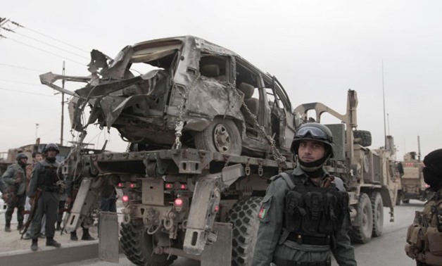 A U.S. military wrecker carries away a vehicle that was destroyed in a suicide car bomb attack on the Jalalabad-Kabul road in Kabul, Afghanistan, Friday, Dec. 27, 2013. The U.S.-led coalition in Afghanistan says several service members were killed Friday 