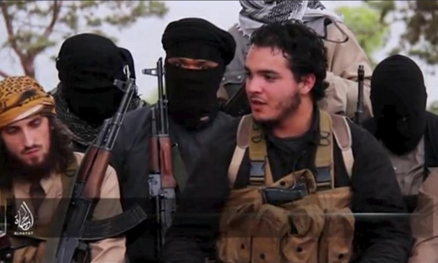 An IS militant who identifies himself as Abu Salman (2nd R) speaks at an undisclosed location, in this still image taken from undated video distributed by IS on November 14, 2015. REUTERS/So