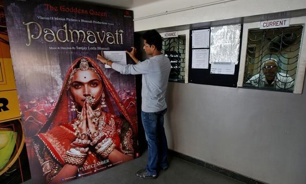 FILE PHOTO: A worker tapes a message in support of the release of the upcoming Bollywood film "Padmavati" on its poster at a ticket selling counter in a cinema hall in Kolkata, India, November 28, 2017. REUTERS/Rupak De Chowdhuri
