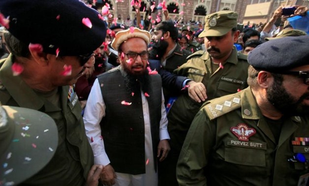 FILE PHOTO: Hafiz Saeed is showered with flower petals as he walks to court before a Pakistani court ordered his release from house arrest in Lahore, Pakistan November 22, 2017. REUTERS/Mohsin Raza
