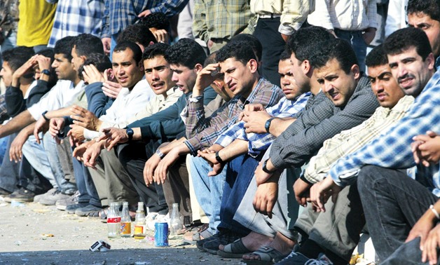 FILE -Unemployed group of youth seen sitting in Cairo