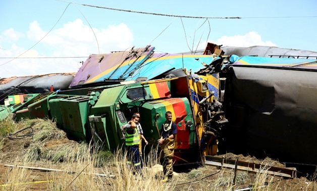 Workers stand next to a wreckage after a train crash near Hennenman in the Free State province, South Africa, January 4, 2018. REUTERS.