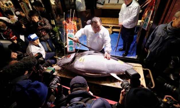 Kiyomura Co's President Kiyoshi Kimura (C), who runs a chain of sushi restaurants Sushi Zanmai, poses with a 190 kg bluefin tuna, priced with a 30.4 million yen bid at the fish market's first tuna auction this year at his sushi restaurant outside Tsukiji 