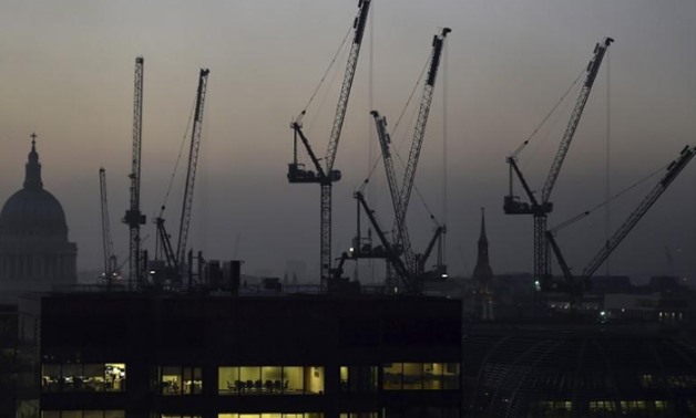 FILE PHOTO: Offices are seen at dusk as St. Paul's Cathedral and construction cranes are seen on the skyline in the City of London, Britain November 2, 2015. REUTERS/Toby Melville