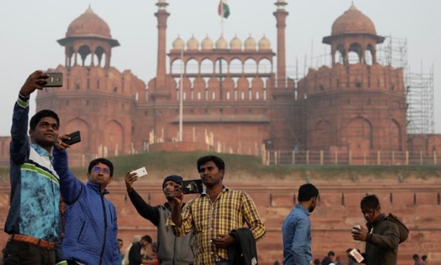 Domestic tourists take selfies in front of the historic Red Fort, one of the tourist destinations in the old quarters of Delhi, India, January 3, 2018.