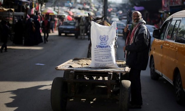 A Palestinian man stands next to a cart carrying a flour sack distributed by the United Nations Relief and Works Agency (UNRWA) in Khan Younis refugee camp in the southern Gaza Strip January 3, 2018. REUTERS/Ibraheem Abu Mustafa