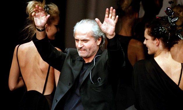 FILE PHOTO: Italian designer Gianni Versace waves at the end of his presentation of his spring-summer '97 ready-to-wear collection at a Milan fashion show, Oct. 5, 1996. REUTERS/Stringer/File Photo