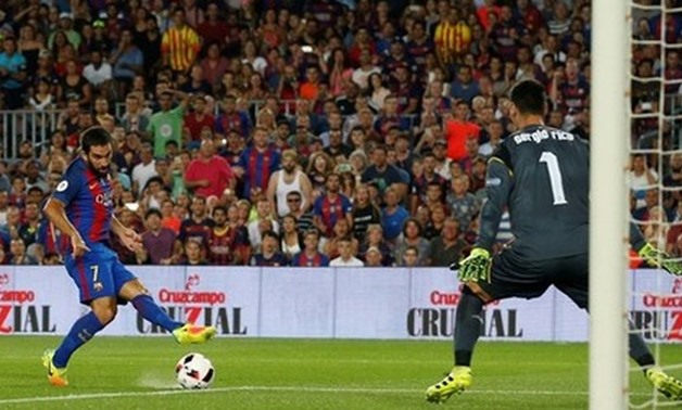 
Barcelona v Sevilla - Spanish SuperCup second leg - Barcelona's Arda Turan scores a goal against Sevilla's goalkeeper Sergio Rico. REUTERS/Albert Gea