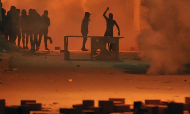 © Sofiene HAMDAOUI / AFP | Tunisian protestors throw stones towards security forces in Tunis' Djebel Lahmer district early on January 10, 2018 after price hikes ignited protests in the North African country.
