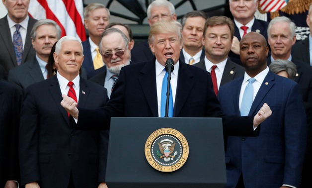 U.S. President Donald Trump speaks flanked by Vice President Mike Pence and Senator Tim Scott (R) as he celebrates with Congressional Republicans after the U.S. Congress passed sweeping tax overhaul legislation, on the South Lawn of the White House in Was