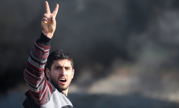 A Palestinian demonstrator gestures during clashes with Israeli troops near the border with Israel in the southern Gaza Strip January 9, 2018. REUTERS/Ibraheem Abu Mustafa