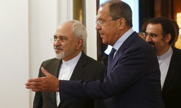Russian Foreign Minister Sergei Lavrov (R) shows the way to his Iranian counterpart Mohammad
