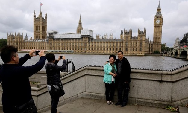 Chinese tourists take pictures near the Big Ben clock tower in London. ( Reuters)
