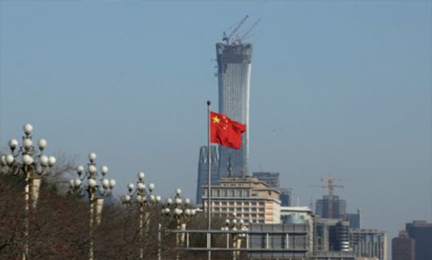 A Chinese flag flutters at Xinhuamen Gate of Zhongnanhai leadership compound in central Beijing, China December 15, 2017. The construction site of China Zun, planned to be the tallest building in Beijing, is seen behind - REUTERS/Jason Lee/File photo