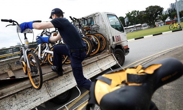 Zhivko Girginov, a Bulgarian living in Singapore, loads up damaged shared bicycles on his lorry to return them to a warehouse after gathering them around his neighbourhood in Singapore, December 29, 2017. REUTERS/Edgar Su
