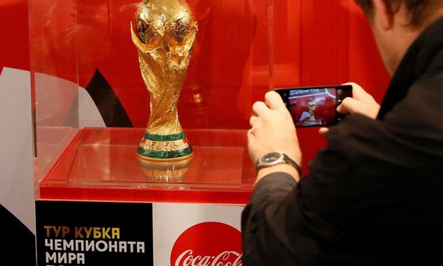 A man takes a picture of the World Cup trophy after a news conference devoted to the FIFA World Cup Trophy Tour in Krasnoyarsk, Siberia, Russia, September 10, 2017. REUTERS/Ilya Naymushin