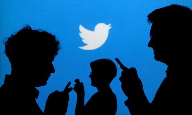 People holding mobile phones are silhouetted against a backdrop projected with the Twitter logo in this illustration picture taken September 27, 2013 -
 REUTERS/Kacper Pempel/Illustration/File Photo