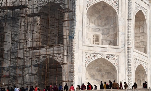 Visitors walk past scaffolding erected for conservation work at the Taj Mahal in the Indian city of Agra January 3, 2018. — AFP 