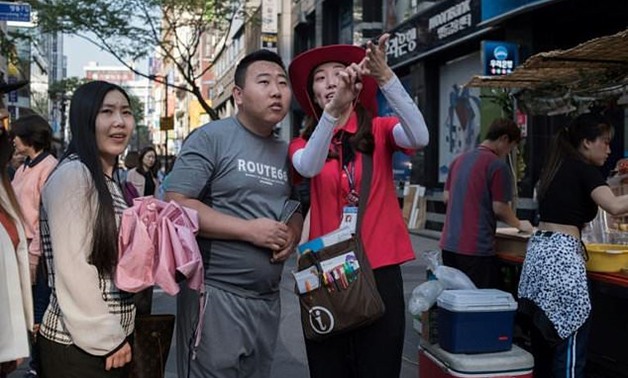 A South Korean guide directs tourists in Seoul's Myeongdong shopping area in May 2017: the number of Chinese visitors continues to fall - AFP