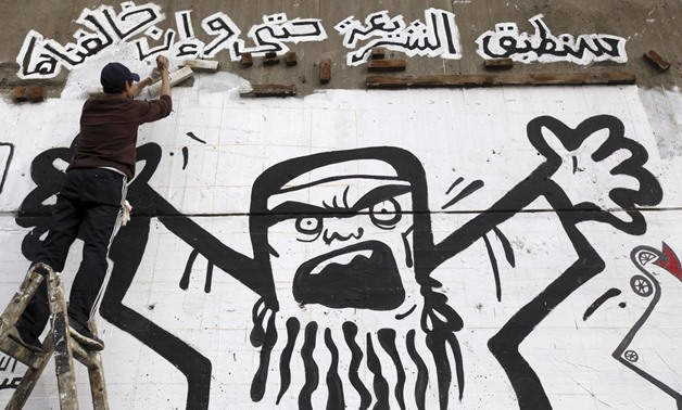 Man works on graffiti representing the Muslim Brotherhood along Mohamed Mahmoud street near Tahrir Square in Cairo, on January 24, 2013- REUTERS/Amr Abdallah Dalsh