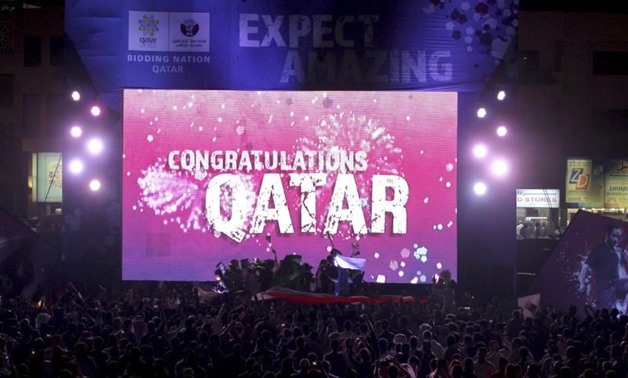 People celebrate in front of a screen that reads "Congratulations Qatar" after FIFA announced that Qatar will be host of the 2022 World Cup in Souq Waqif in Doha, December 2, 2010. REUTERS/Fadi Al-Assaad
